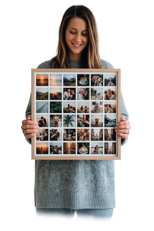 A customer smiling while holding a FreeSnaps framed photo collage