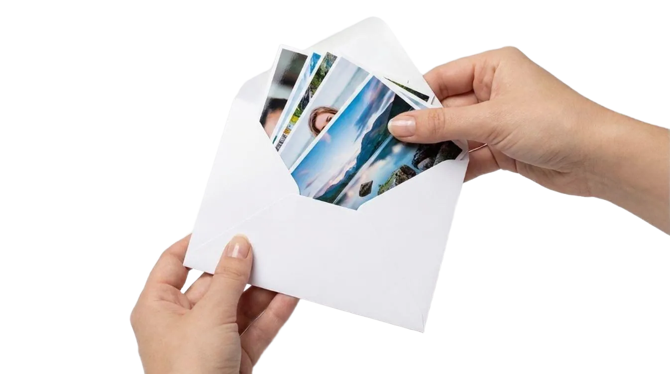 Free photo prints UK: a hand holding a stack of 6x4 prints from FreeSnaps