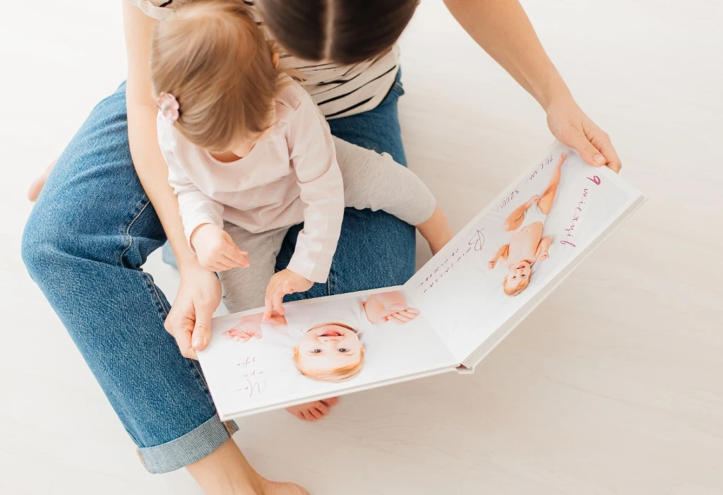 Parent and child looking through a personalised photo book together