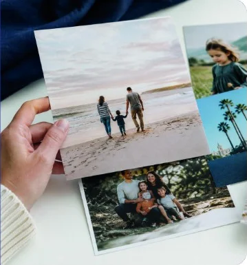 Customer holding FreeSnaps photo prints of family holiday photos